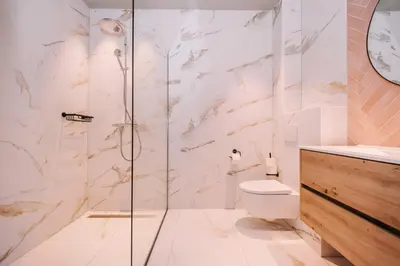 a bathroom with a toilet and a glass shower at Hotel Keur - Apartments in Zandvoort