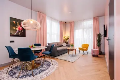 a living room with a couch and a table and chairs at Hotel Keur - Apartments in Zandvoort