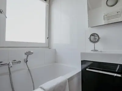 a white bathroom with a shower and a sink at Dorregeest in Uitgeest