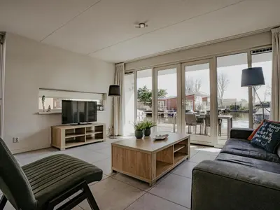 a living room with a couch and a tv at Dorregeest in Uitgeest
