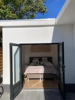a bedroom with a bed under a white wall at Noordster Beachhouse, Noordwijk aan Zee in Noordwijk