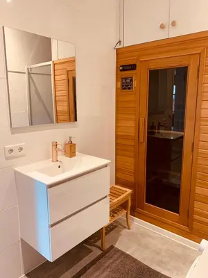 a bathroom with a white sink and a mirror at Noordster Beachhouse, Noordwijk aan Zee in Noordwijk