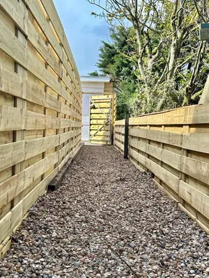 a wooden fence with a gate and a driveway at Noordster Beachhouse, Noordwijk aan Zee in Noordwijk