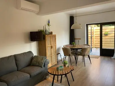 a living room with a couch and a table at Noordster Beachhouse, Noordwijk aan Zee in Noordwijk