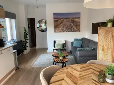 a living room with a couch and a table at Noordster Beachhouse, Noordwijk aan Zee in Noordwijk