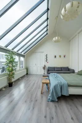 a bedroom with a bed and a large skylight at Penthouse Amsterdam Dam Square in Amsterdam