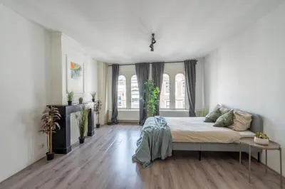 a bedroom with a bed in a white room at Penthouse Amsterdam Dam Square in Amsterdam