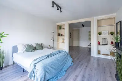 a bedroom with a bed in a white room at Penthouse Amsterdam Dam Square in Amsterdam