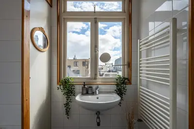 a bathroom with a sink and a window at Penthouse Amsterdam Dam Square in Amsterdam