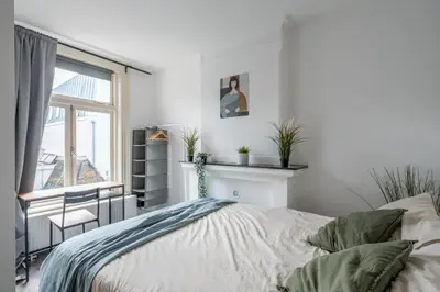 a bedroom with a bed and a window at Penthouse Amsterdam Dam Square in Amsterdam