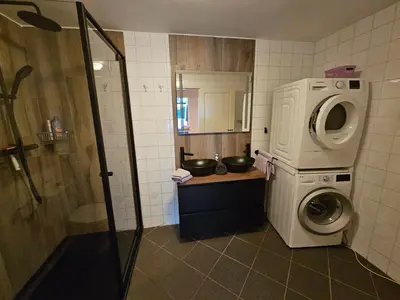 a bathroom with a washing machine and a washer at B&B Schiphol Amsterdam in Rijsenhout