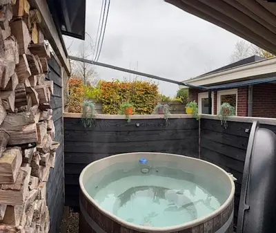 a jacuzzi tub in a yard next to a building at B&B Schiphol Amsterdam in Rijsenhout