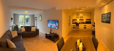 a living room with a couch and a tv at B&B Schiphol Amsterdam in Rijsenhout
