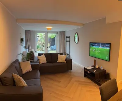 a living room with a couch and a flat screen tv at B&B Schiphol Amsterdam in Rijsenhout