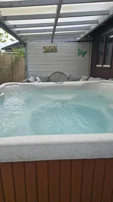 a large hot tub in a backyard with at Balistyle guesthouse incl Jacuzzi near Amsterdam and Schiphol in Vijfhuizen