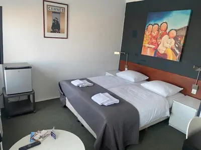 a hotel room with two beds and a tv at Hotel Anna in Zandvoort