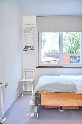 a bedroom with a bed and a window at The Amsterdam Houseboat Family - de Pijp in Amsterdam
