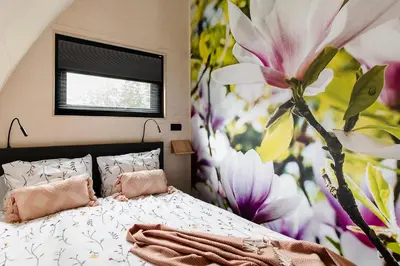 a bedroom with a bed with a large flower mural at GreenFloat Boskoop #2 in Boskoop