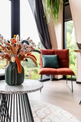a room with a table with a vase with flowers at GreenFloat Boskoop #2 in Boskoop
