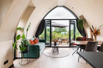 an arched window in a living room with a couch at GreenFloat Boskoop #2 in Boskoop