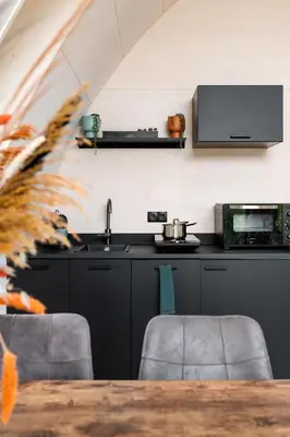 a kitchen with black cabinets and a sink and a counter at GreenFloat Boskoop #2 in Boskoop