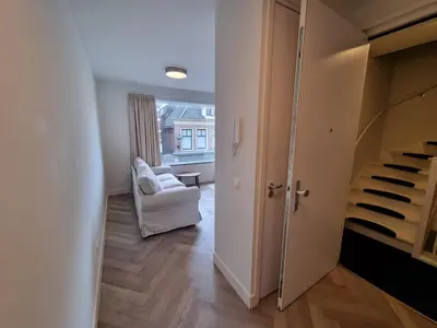 a hallway with a staircase and a chair in a room at Molenzicht in Alkmaar