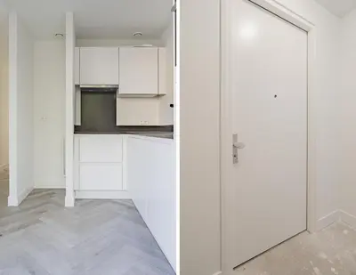 a kitchen with white cabinets and a sliding door at Molenzicht in Alkmaar