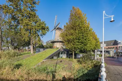 a windmill in the middle of a city at Molenzicht in Alkmaar