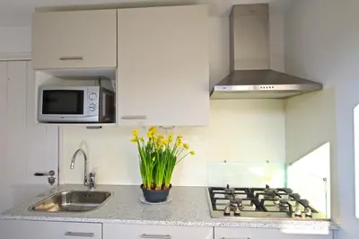 a kitchen with a sink and a stove top oven at Studio Eb in Egmond aan Zee