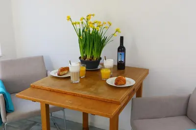a table with two plates of food and a bottle of wine at Studio Eb in Egmond aan Zee