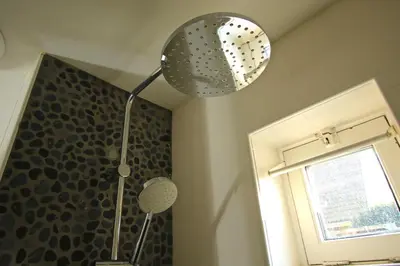 a shower in a bathroom with a shower curtain at Zomerhuis Flow in Egmond aan Zee