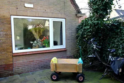 a wheelbarrow sitting in front of a window at Zomerhuis Flow in Egmond aan Zee