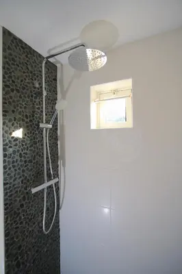 a bathroom with a shower with a glass door at Zomerhuis Flow in Egmond aan Zee