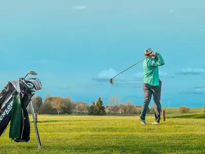 a man swinging a golf club in a field at Scilla in Soesterberg