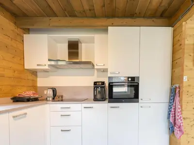 a kitchen with white cabinets and a wooden ceiling at Scilla in Soesterberg