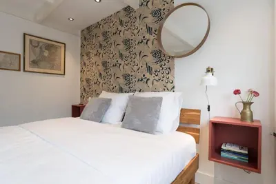 a bedroom with a bed with a mirror on the wall at Pakhuis aan de Zaan in Wormerveer