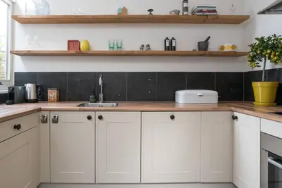 a kitchen with white cabinets and wooden counter tops at Pakhuis aan de Zaan in Wormerveer