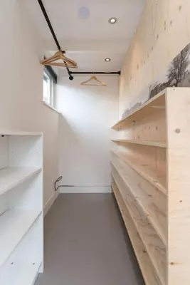 a walk in closet with white walls and wooden shelves at Pakhuis aan de Zaan in Wormerveer