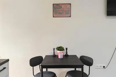 a table with four chairs and a plant on it at Milis Beach Cottage in Zandvoort
