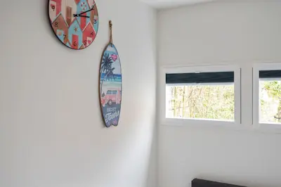 a clock on a wall next to two windows at Milis Beach Cottage in Zandvoort