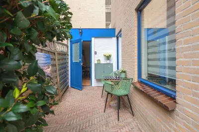 a small patio with a table and chairs on a building at Milis Beach Cottage in Zandvoort
