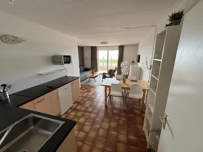 a kitchen and living room with a table and chairs at Villa aan Zee in Noordwijk