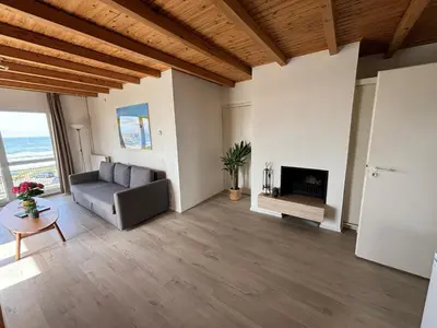 a living room with a couch and a fireplace at Villa aan Zee in Noordwijk