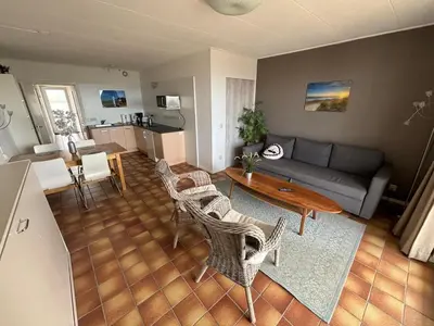 a living room with a couch and a table and chairs at Villa aan Zee in Noordwijk