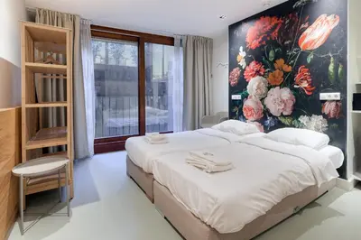 a bedroom with a large bed with a floral wall at Marnix360apartments The Mansion Suites in Amsterdam