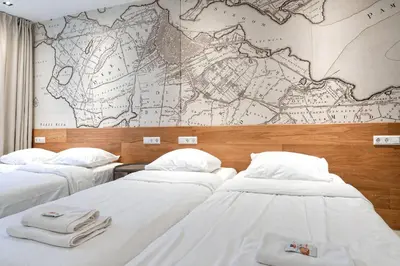 a room with three beds and a map on the wall at Marnix360apartments The Mansion Suites in Amsterdam