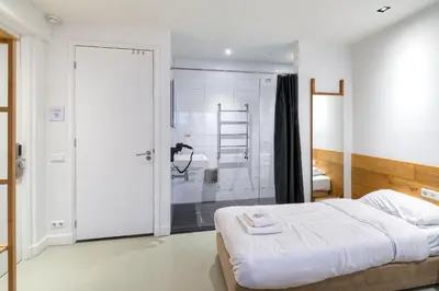 a bedroom with a bed and a bathroom with a shower at Marnix360apartments The Mansion Suites in Amsterdam