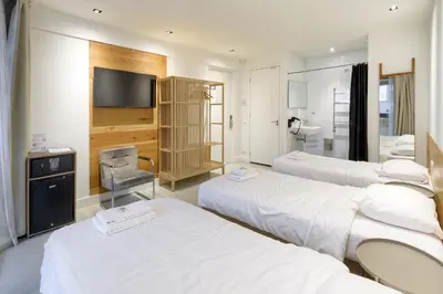 a hospital room with three beds and a flat screen tv at Marnix360apartments The Mansion Suites in Amsterdam