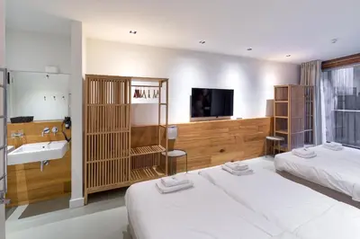 a hotel room with two beds and a sink and a bathroom at Marnix360apartments The Mansion Suites in Amsterdam