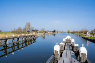 a view of a river with a dock in the water at Aan de Amstel in De Kwakel